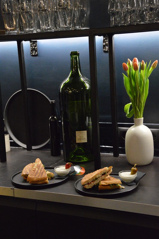 Ciabatta snacks, a big wine bottle and tulips on the counter