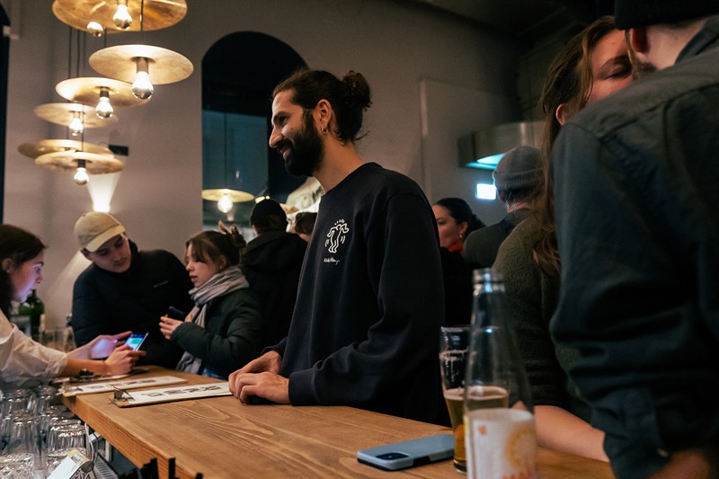 Our host serving guests at the wooden counter