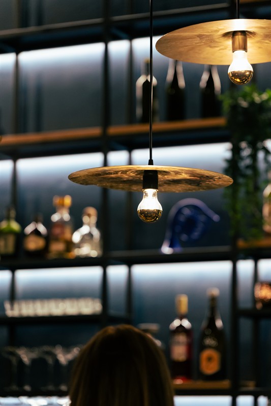 Cymbal lamps in front of the backlit shelves
