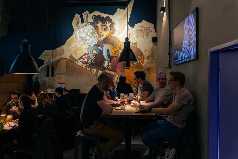 Tables full of guests in front of the mural